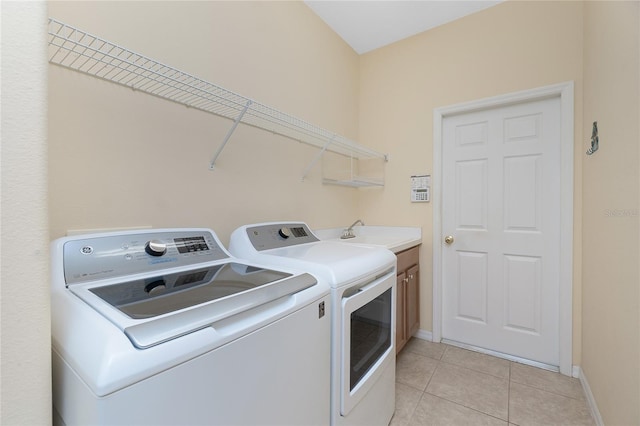 117 Abercrombie Ave, Englewood, FL 34223 - laundry area featuring washing machine and clothes dryer, cabinet space, and light tile patterned floors