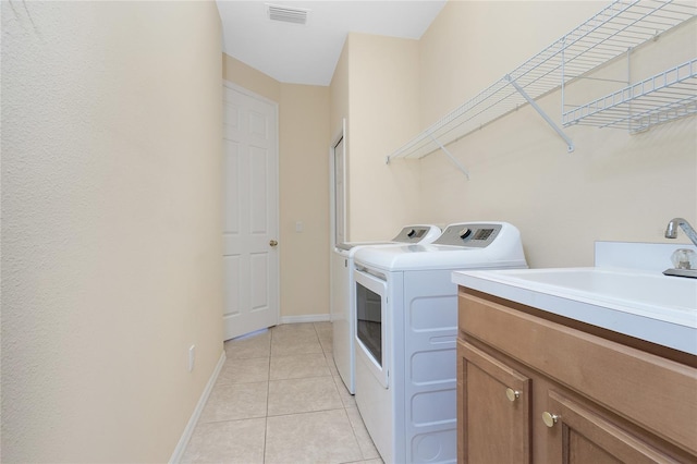 117 Abercrombie Ave, Englewood, FL 34223 - laundry area with washer and dryer, cabinet space, and light tile patterned floors