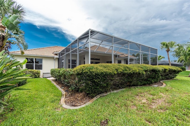 117 Abercrombie Ave, Englewood, FL 34223 - rear view of property with stucco siding, a yard, a tiled roof, and a lanai