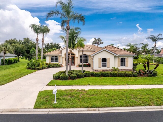 117 Abercrombie Ave, Englewood, FL 34223 - mediterranean / spanish house with stucco siding, a tiled roof, concrete driveway, and a front yard