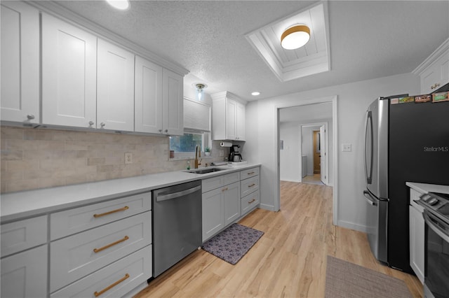 1730 Bluebird Ln, Englewood, FL 34224 - kitchen featuring stainless steel appliances, light wood finished floors, tasteful backsplash, light countertops, and a textured ceiling