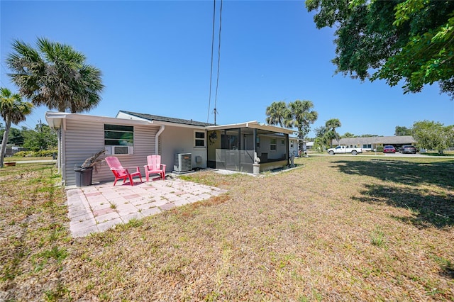 1730 Bluebird Ln, Englewood, FL 34224 - back of property featuring a sunroom, a patio area, and a lawn