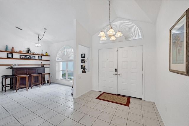 727 Rotonda Cir, Rotonda West, FL 33947 - foyer featuring a chandelier, lofted ceiling, light tile patterned floors, and bar area