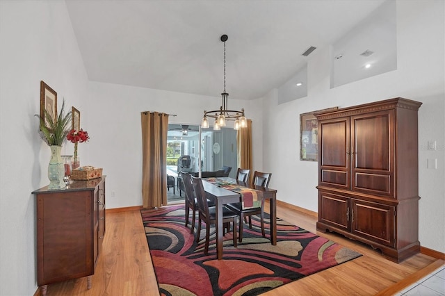727 Rotonda Cir, Rotonda West, FL 33947 - dining space with a chandelier, light wood-type flooring, and high vaulted ceiling