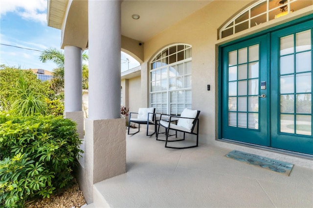 39 Pine Valley Ct, Rotonda West, FL 33947 - property entrance with french doors, stucco siding, and a porch