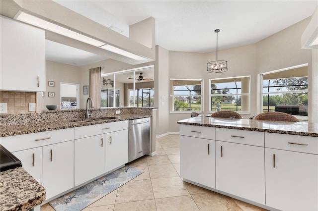 39 Pine Valley Ct, Rotonda West, FL 33947 - kitchen with stainless steel dishwasher, stone counters, plenty of natural light, and white cabinets