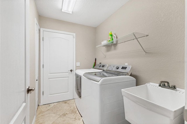 39 Pine Valley Ct, Rotonda West, FL 33947 - laundry room with washing machine and clothes dryer, a textured wall, and light tile patterned floors