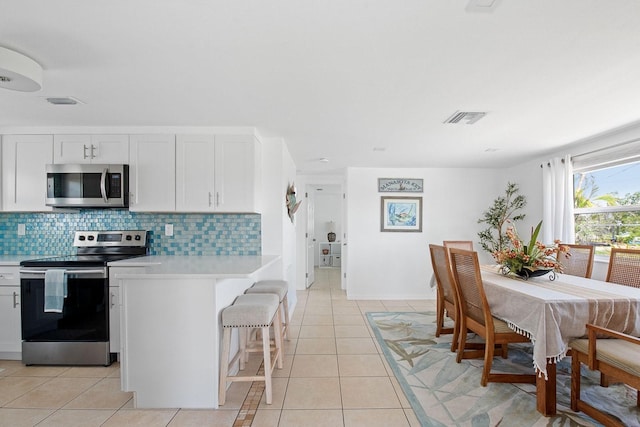 1060 Haste Ln, Englewood, FL 34223 - kitchen with appliances with stainless steel finishes, light countertops, backsplash, and light tile patterned flooring