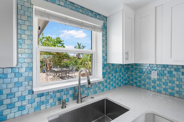 1060 Haste Ln, Englewood, FL 34223 - kitchen featuring decorative backsplash, white cabinets, and light stone countertops