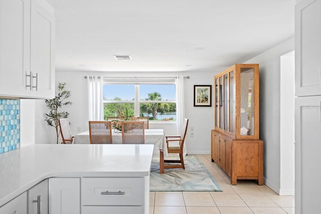 1060 Haste Ln, Englewood, FL 34223 - kitchen with light countertops, white cabinets, and light tile patterned flooring