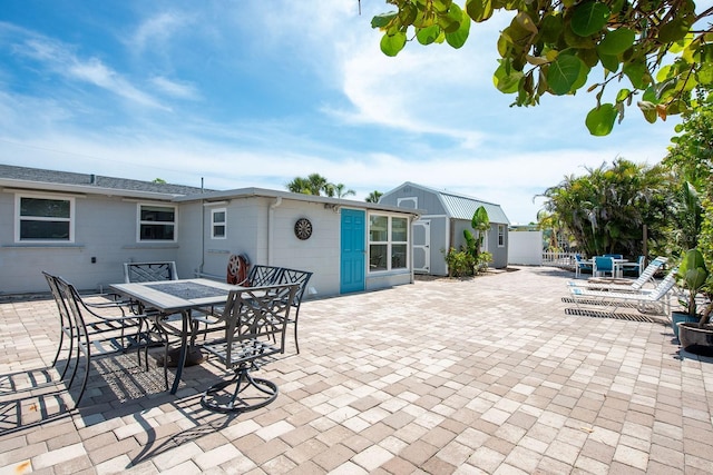 1060 Haste Ln, Englewood, FL 34223 - view of patio featuring outdoor dining space and a shed