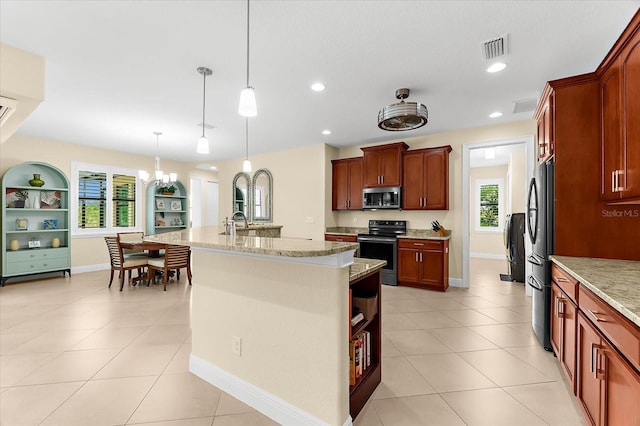 10029 Boylston St, Port Charlotte, FL 33981 - kitchen with stainless steel appliances, a center island with sink, pendant lighting, light tile patterned floors, and light stone counters