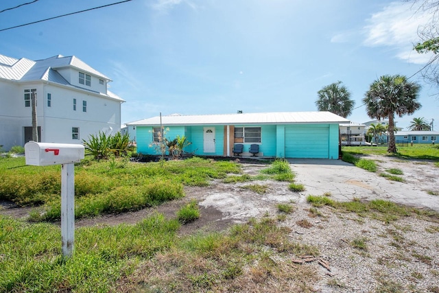 10452 Raymond St, Englewood, FL 34224 - view of front of property with a metal roof, a garage, and driveway