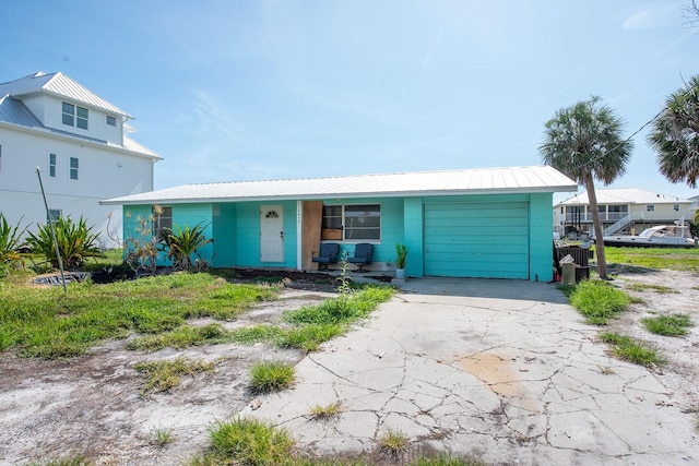 10452 Raymond St, Englewood, FL 34224 - view of front of house featuring a garage, a metal roof, and concrete driveway