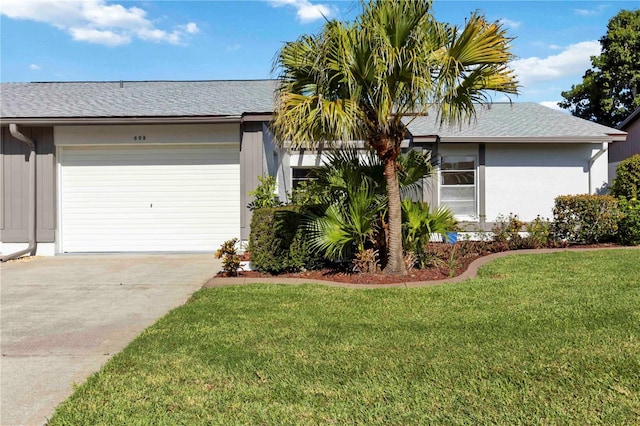 609 Deerwood Ave, Englewood, FL 34223 - view of front of home featuring concrete driveway, an attached garage, a front yard, and roof with shingles
