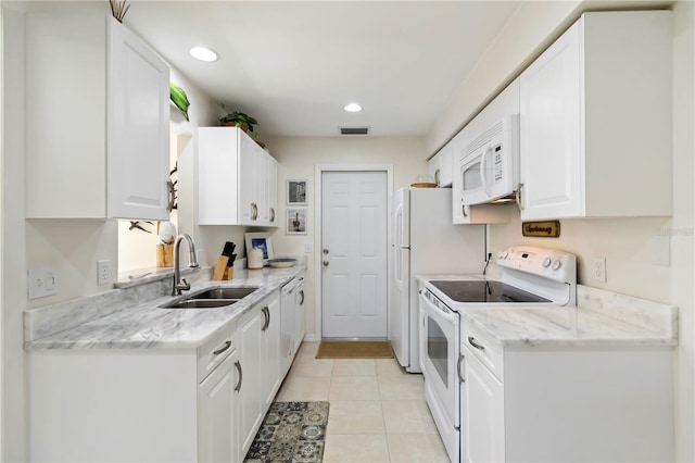 609 Deerwood Ave, Englewood, FL 34223 - kitchen featuring white appliances, white cabinetry, light tile patterned floors, light stone counters, and recessed lighting