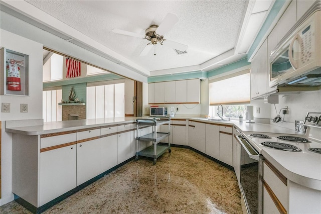609 Deerwood Ave, Englewood, FL 34223 - kitchen featuring white appliances, a textured ceiling, light countertops, a ceiling fan, and white cabinets