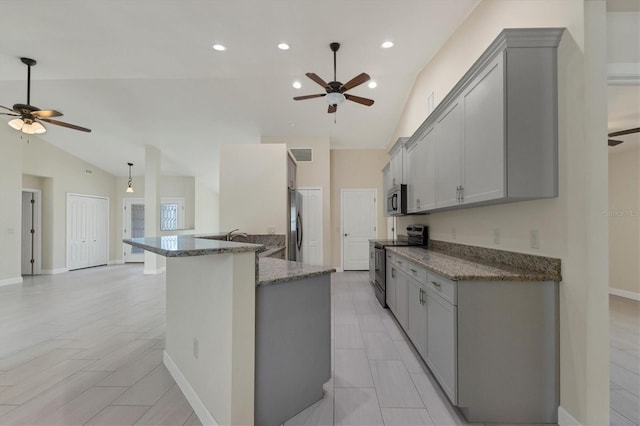5781 Elton Rd, Venice, FL 34293 - kitchen with stainless steel appliances, ceiling fan, vaulted ceiling, gray cabinetry, and stone countertops