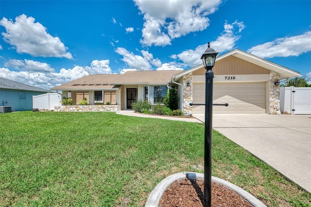 7218 Darlington St, Englewood, FL 34224 - ranch-style house featuring an attached garage, concrete driveway, a gate, and stone siding