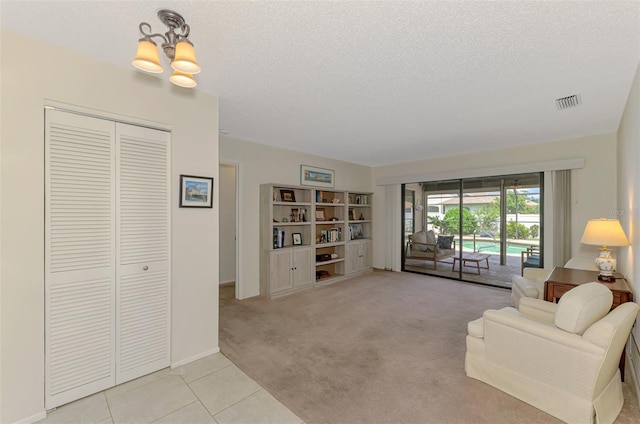 7218 Darlington St, Englewood, FL 34224 - sitting room with a chandelier, a textured ceiling, light tile patterned floors, and light colored carpet