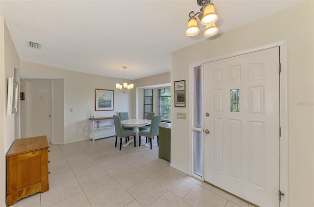 7218 Darlington St, Englewood, FL 34224 - entrance foyer featuring a chandelier, light tile patterned floors, and a textured ceiling