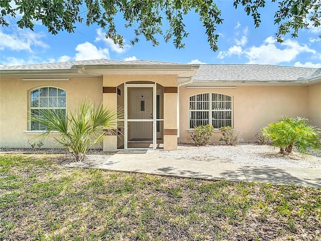 104 Mark Twain Ln, Rotonda West, FL 33947 - entrance to property featuring stucco siding and a shingled roof
