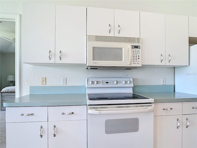 104 Mark Twain Ln, Rotonda West, FL 33947 - kitchen with white appliances, light countertops, and white cabinetry