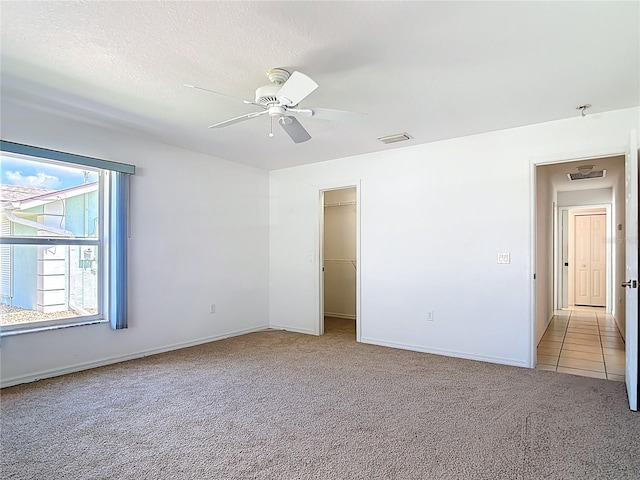 104 Mark Twain Ln, Rotonda West, FL 33947 - unfurnished bedroom featuring carpet flooring, ceiling fan, a walk in closet, and a closet