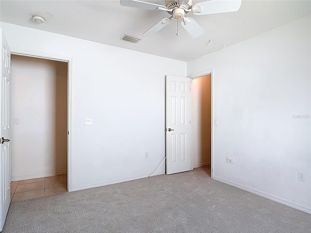 104 Mark Twain Ln, Rotonda West, FL 33947 - empty room with a smoke detector, ceiling fan, tile patterned flooring, and carpet