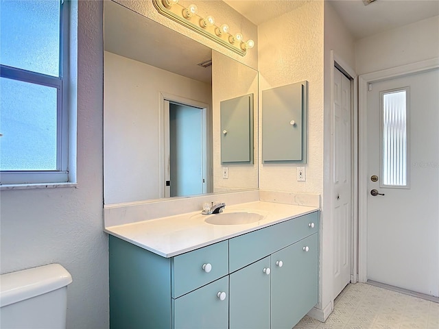 104 Mark Twain Ln, Rotonda West, FL 33947 - bathroom featuring healthy amount of natural light, vanity, tile patterned floors, a textured wall, and a closet