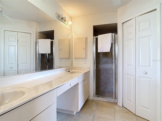104 Mark Twain Ln, Rotonda West, FL 33947 - full bath featuring double vanity, a shower stall, tile patterned floors, a closet, and a ceiling fan