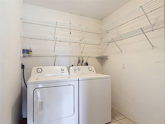 104 Mark Twain Ln, Rotonda West, FL 33947 - laundry room featuring washer and clothes dryer and light tile patterned floors