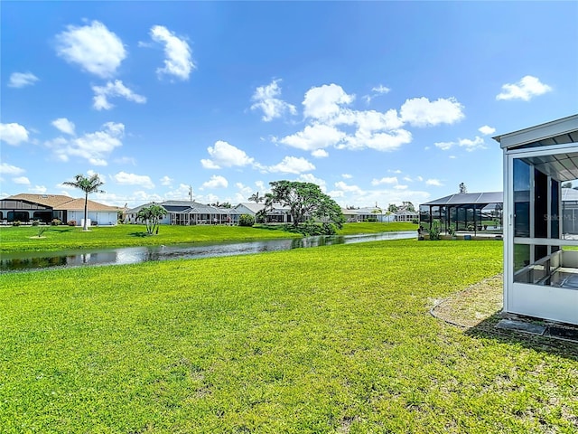104 Mark Twain Ln, Rotonda West, FL 33947 - view of grassy yard with a water view, a residential view, and glass enclosure