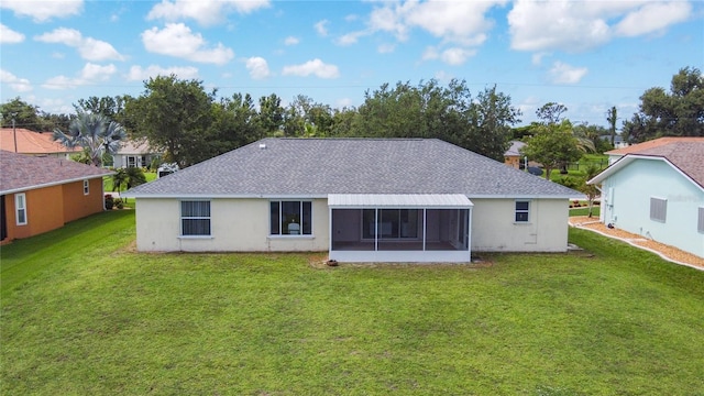 104 Mark Twain Ln, Rotonda West, FL 33947 - rear view of house with roof with shingles, a yard, a sunroom, and stucco siding