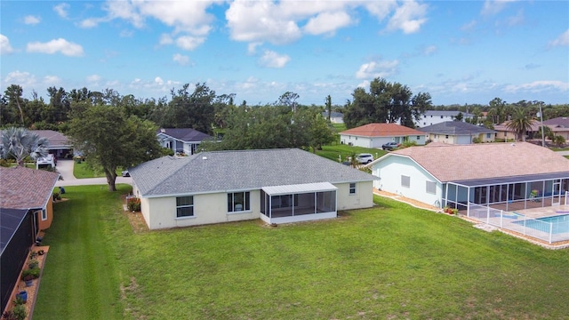 104 Mark Twain Ln, Rotonda West, FL 33947 - rear view of property featuring a sunroom, a lawn, a residential view, and a shingled roof