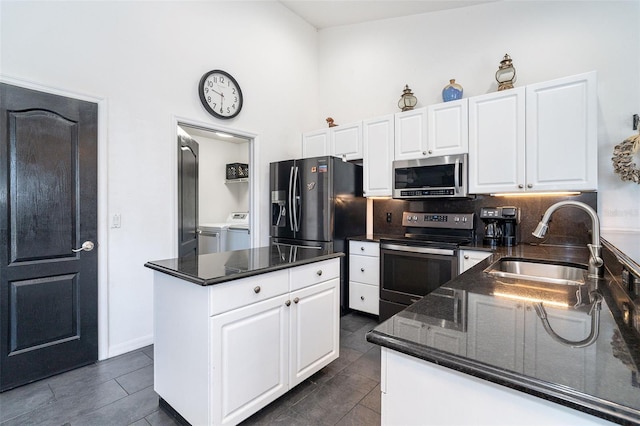 7376 Stetson Ln, Port Charlotte, FL 33981 - kitchen featuring stainless steel appliances, washer and dryer, white cabinets, dark stone countertops, and a high ceiling
