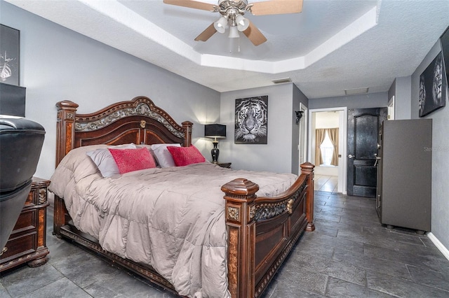 7376 Stetson Ln, Port Charlotte, FL 33981 - bedroom featuring ceiling fan, a tray ceiling, and stone finish floors