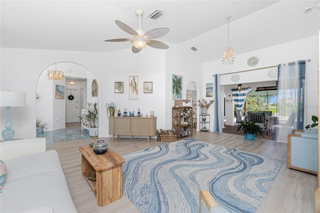 926 Boundary Blvd, Rotonda West, FL 33947 - living room with arched walkways, a chandelier, a ceiling fan, wood finished floors, and high vaulted ceiling