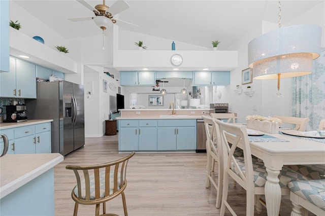 926 Boundary Blvd, Rotonda West, FL 33947 - kitchen featuring blue cabinetry, appliances with stainless steel finishes, light countertops, and lofted ceiling