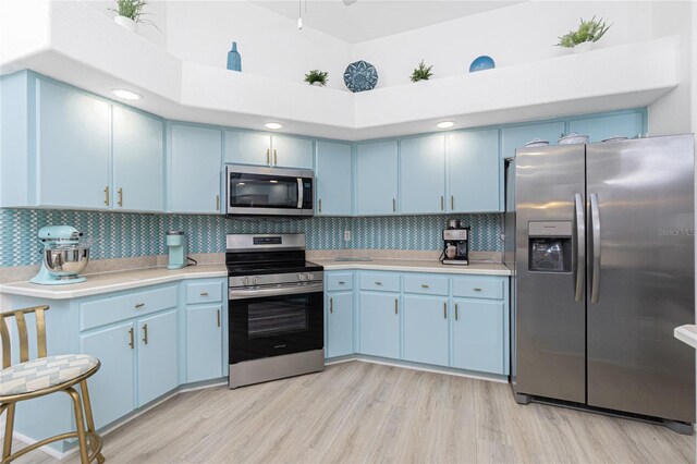926 Boundary Blvd, Rotonda West, FL 33947 - kitchen with appliances with stainless steel finishes, blue cabinetry, light countertops, and light wood-style floors