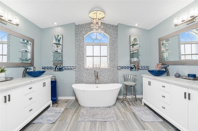 926 Boundary Blvd, Rotonda West, FL 33947 - bathroom featuring vanity, a soaking tub, healthy amount of natural light, lofted ceiling, and wood finish floors