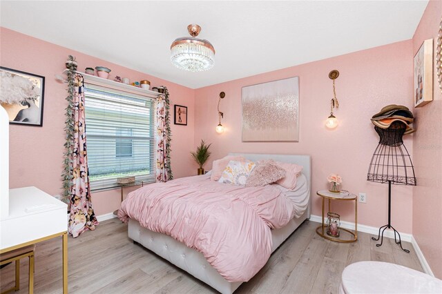 926 Boundary Blvd, Rotonda West, FL 33947 - bedroom with light wood-style floors and a chandelier