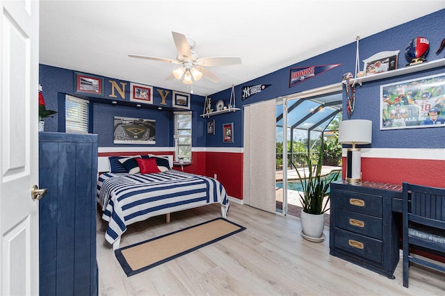 926 Boundary Blvd, Rotonda West, FL 33947 - bedroom with wood finished floors, a textured wall, a wainscoted wall, a ceiling fan, and access to outside