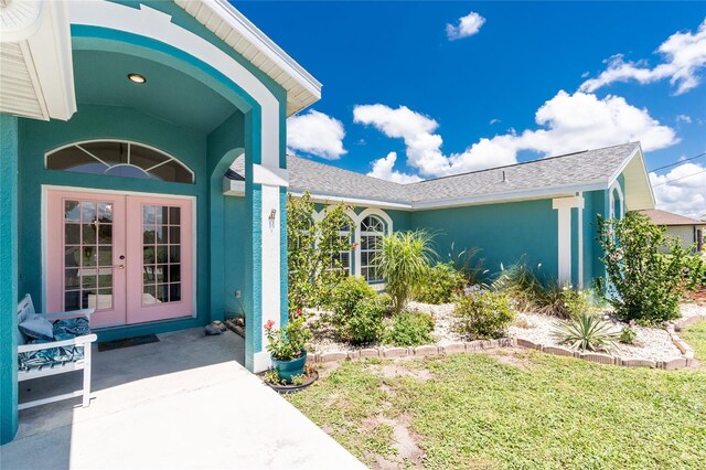 926 Boundary Blvd, Rotonda West, FL 33947 - entrance to property with french doors, stucco siding, and a yard