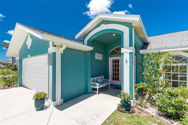 926 Boundary Blvd, Rotonda West, FL 33947 - property entrance with a garage, roof with shingles, concrete driveway, and stucco siding