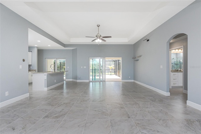 6 Medalist Ct, Rotonda West, FL 33947 - empty room with a tray ceiling, ceiling fan, arched walkways, recessed lighting, and light marble finish floors