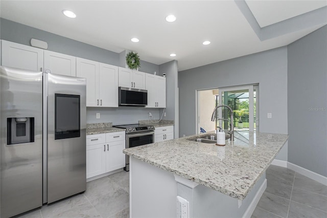 6 Medalist Ct, Rotonda West, FL 33947 - kitchen with stainless steel appliances, white cabinets, light stone counters, recessed lighting, and a center island with sink