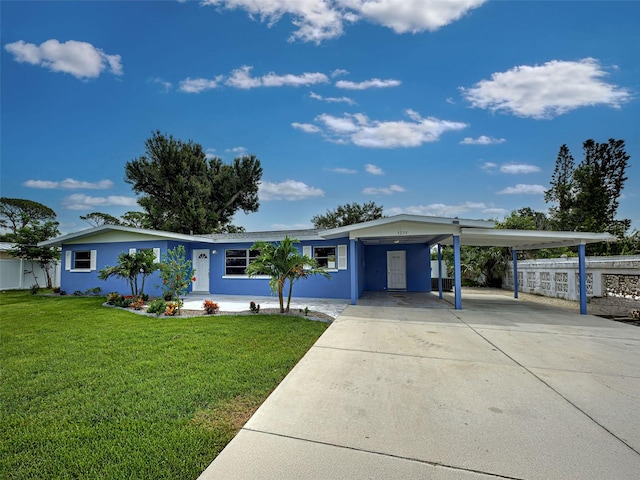 1295 S Maryknoll Rd, Englewood, FL 34223 - ranch-style house with a carport, driveway, a front yard, and stucco siding