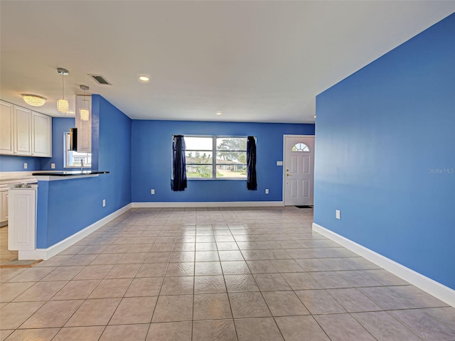 1295 S Maryknoll Rd, Englewood, FL 34223 - kitchen featuring open floor plan, a peninsula, light tile patterned floors, white cabinetry, and recessed lighting