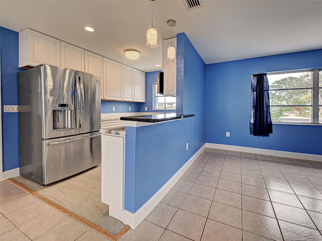 1295 S Maryknoll Rd, Englewood, FL 34223 - kitchen featuring stainless steel refrigerator with ice dispenser, a peninsula, white cabinetry, hanging light fixtures, and light tile patterned floors